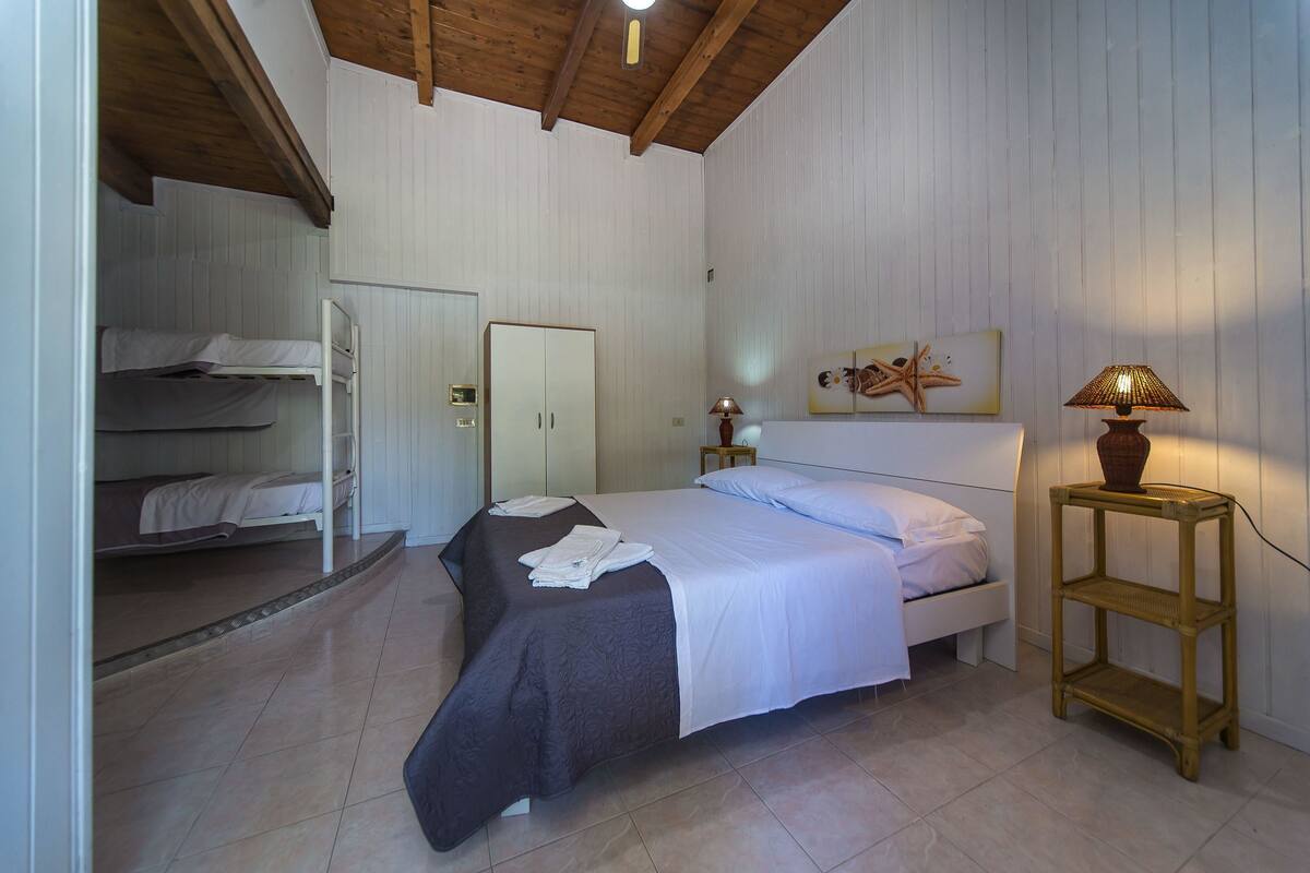 Une chambre à coucher avec un lit, une armoire, une table de chevet et une lampe.