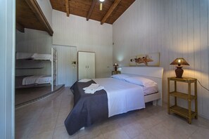 Une chambre à coucher avec un lit, une armoire, une table de chevet et une lampe.
