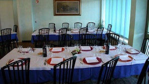 A conference room with multiple tables set for dining, chairs, and a painting on the wall. - Hotel Palladio (San Fior di Sopra)