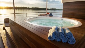 A hot tub on a wooden deck with a view of a lake and sunset. - Jungle Experiences Zafiro (Nauta)