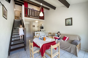 A dining area with a table, chairs, and a staircase. - Le Moulin de Sournia - Gites (Sournia)