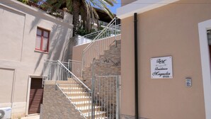 Un immeuble d’habitation avec un escalier, une porte fermée et une pancarte sur le mur.