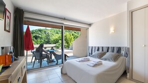 Ein Hotelzimmer mit Bett, Schreibtisch, Stuhl und Blick ins Freie.