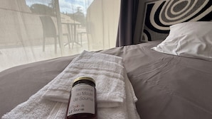 Ein Bett mit einem weißen Handtuch und einer Weinflasche darauf.