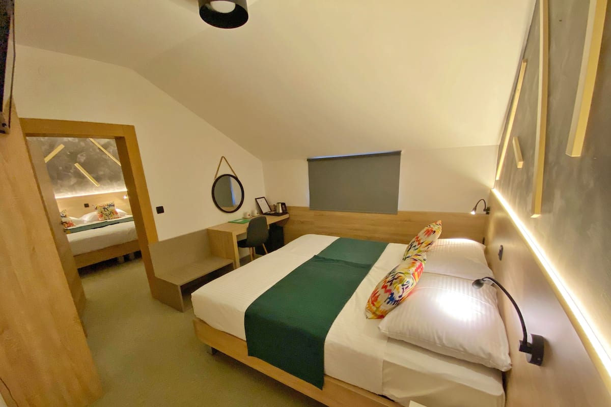 A compact, modern room with a single bed, a desk, and a small seating area.