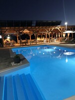 Una piscina con solárium de madera y zona de estar al aire libre.