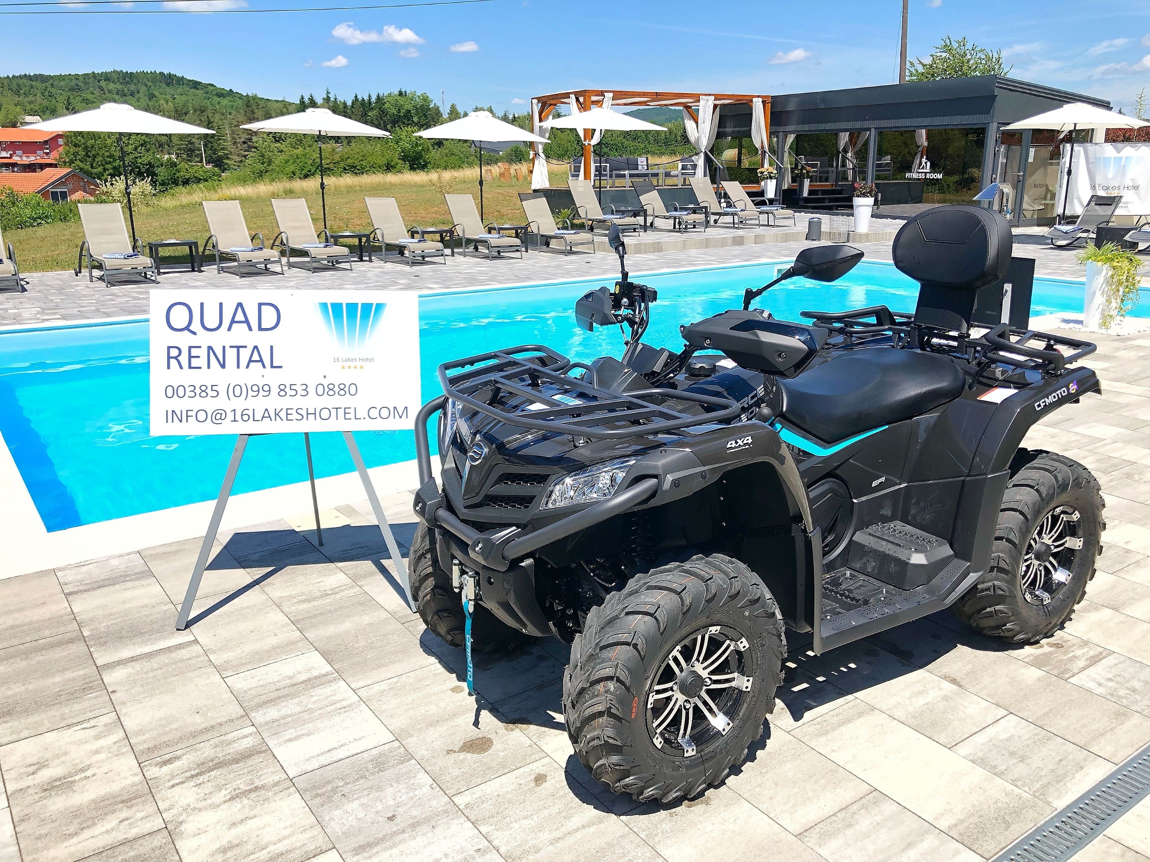 Sinal de aluguel de veículo todo-terreno perto de uma piscina com espreguiçadeiras e guarda-sóis.