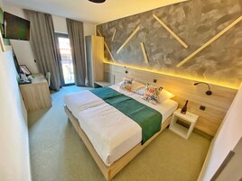 Una habitación de hotel moderna con una cama grande, un escritorio y una zona de estar.