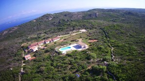 An aerial view of a property with a swimming pool, multiple buildings, and a mountainous backdrop. - Brise Marine (Bonifacio)