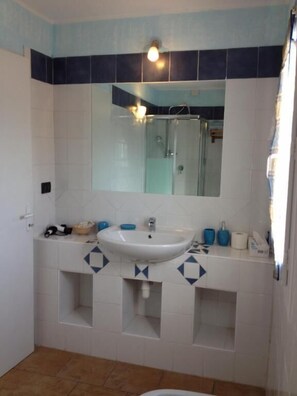 A bathroom with a white sink, a mirror, and a shower. - Brise Marine (Bonifacio)