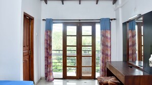 A room with a wooden door, a large window with curtains, a mirror, and a bed. - Hotel Hill View (Hatton)