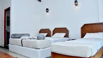 Een hotelkamer met twee bedden, een slaapbank en een houten vloer.