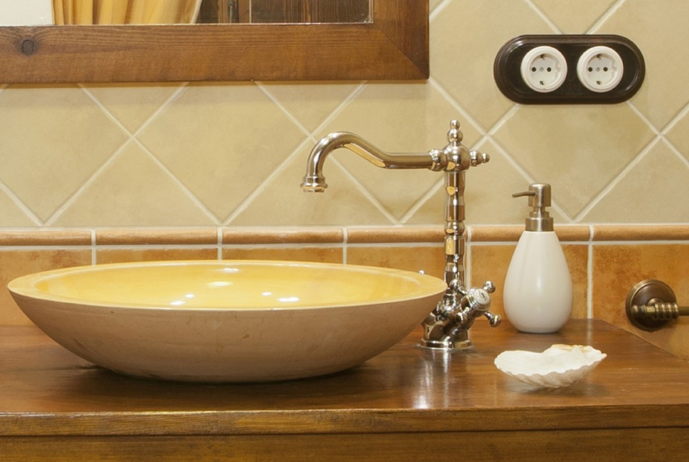 A bathroom sink with a vintage faucet, a soap dispenser, and a towel holder.