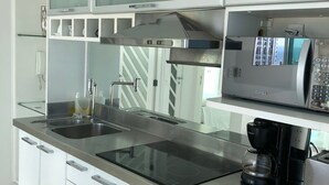 A modern kitchen with a stainless steel countertop, a built-in oven, and a coffee maker. - My Rio Penthouse Ipanema Beach (Rio de Janeiro)