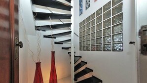 A staircase with black steps and white walls, leading to a door with a glass panel. - My Rio Penthouse Ipanema Beach (Rio de Janeiro)