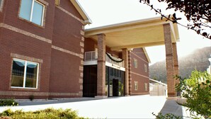 A multi-story brick building with a covered entrance and large windows. - Zion's Most Wanted Hotel (Hildale)