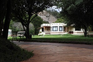 A building with a porch, a bench, and a pathway. - Hotel Bosques del Sol Suites (San Cristóbal de las Casas)