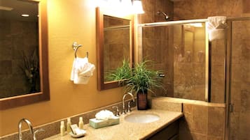 A bathroom with two sinks, a mirror, a towel rack, and a potted plant.