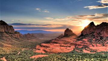 A desert landscape with red rock formations and green vegetation.