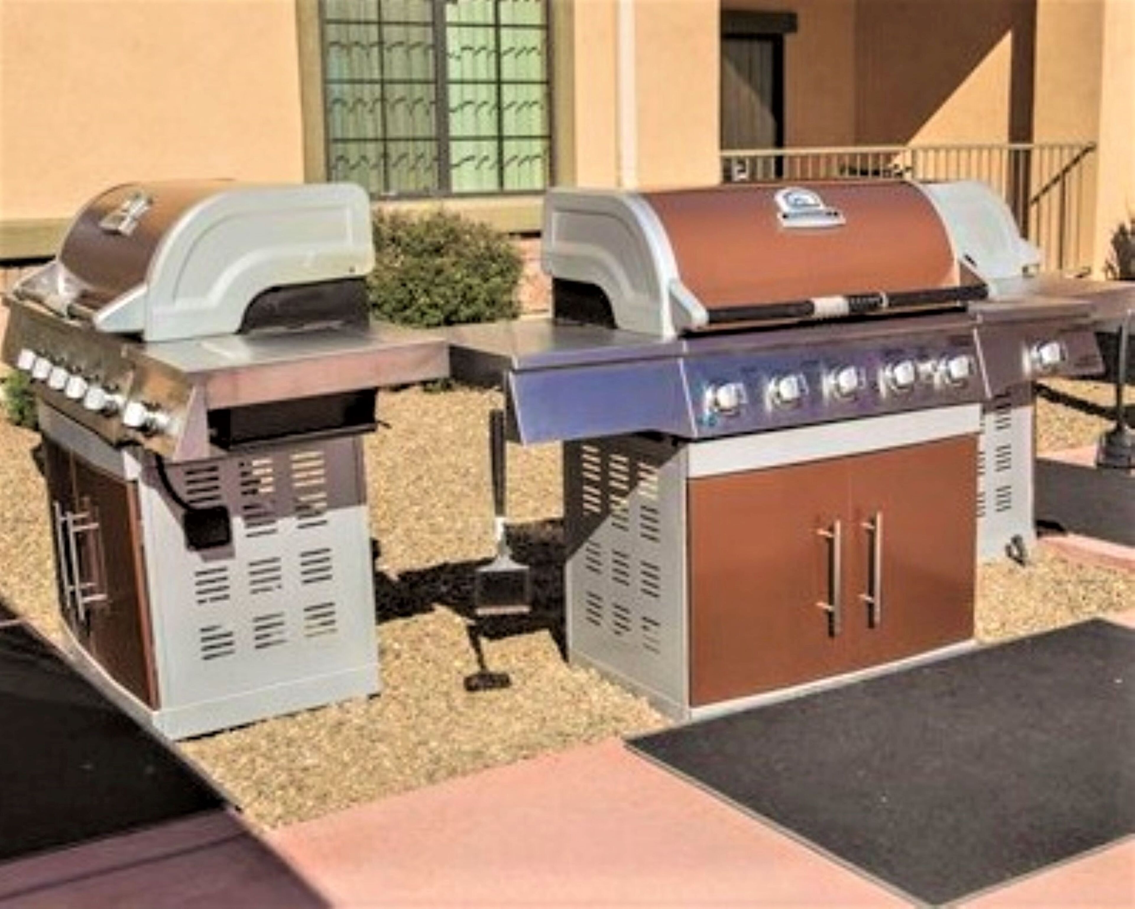 Un barbecue doté d’un meuble latéral et d’un panneau de commande, installé à l’extérieur.