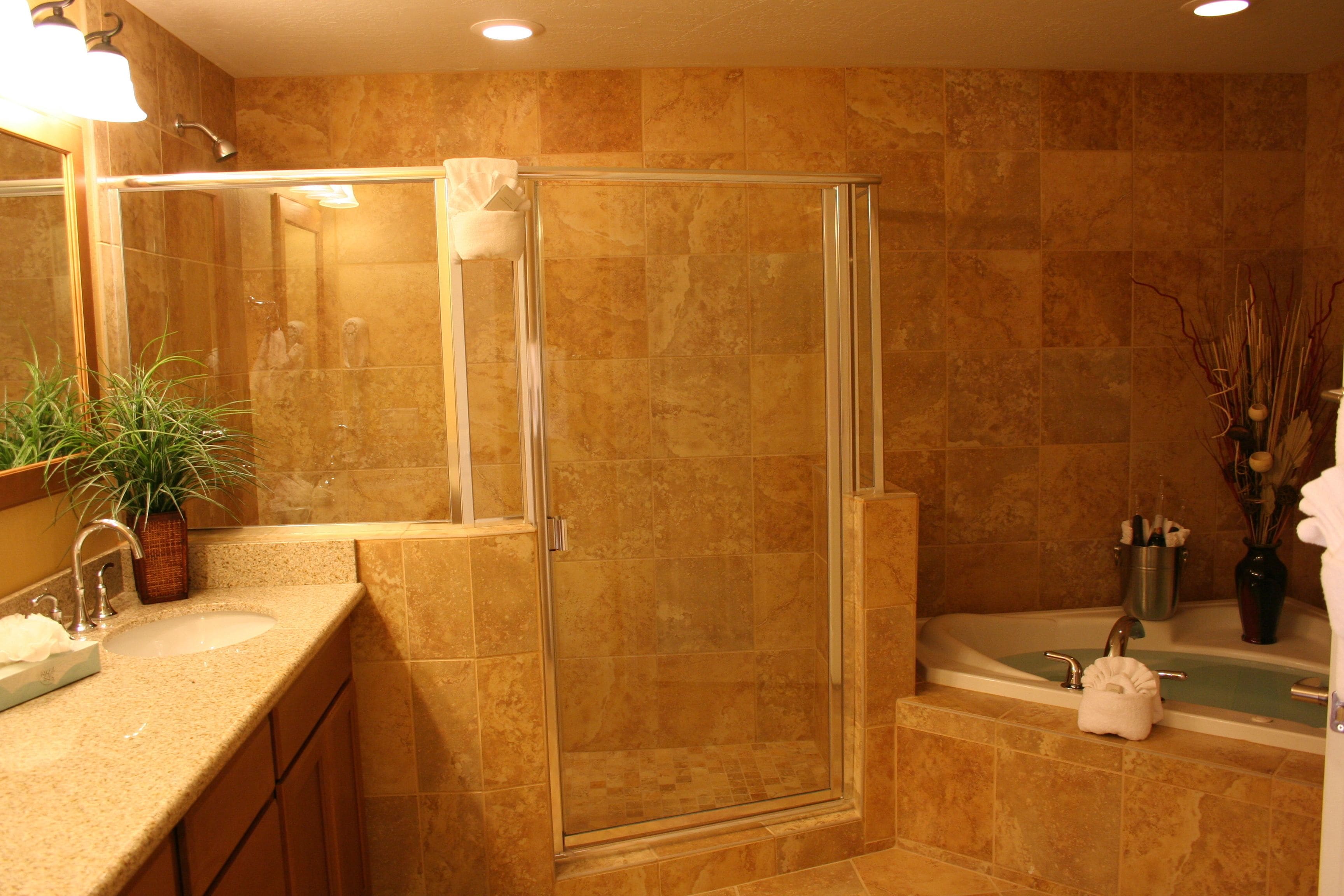 A bathroom with a glass-enclosed shower, a sink with a mirror, and a bathtub.