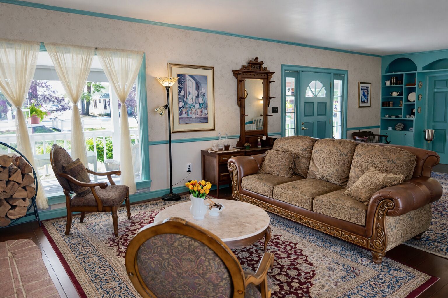 A traditional living room with a sofa, chairs, a coffee table, a fireplace, and a view of the outdoors.