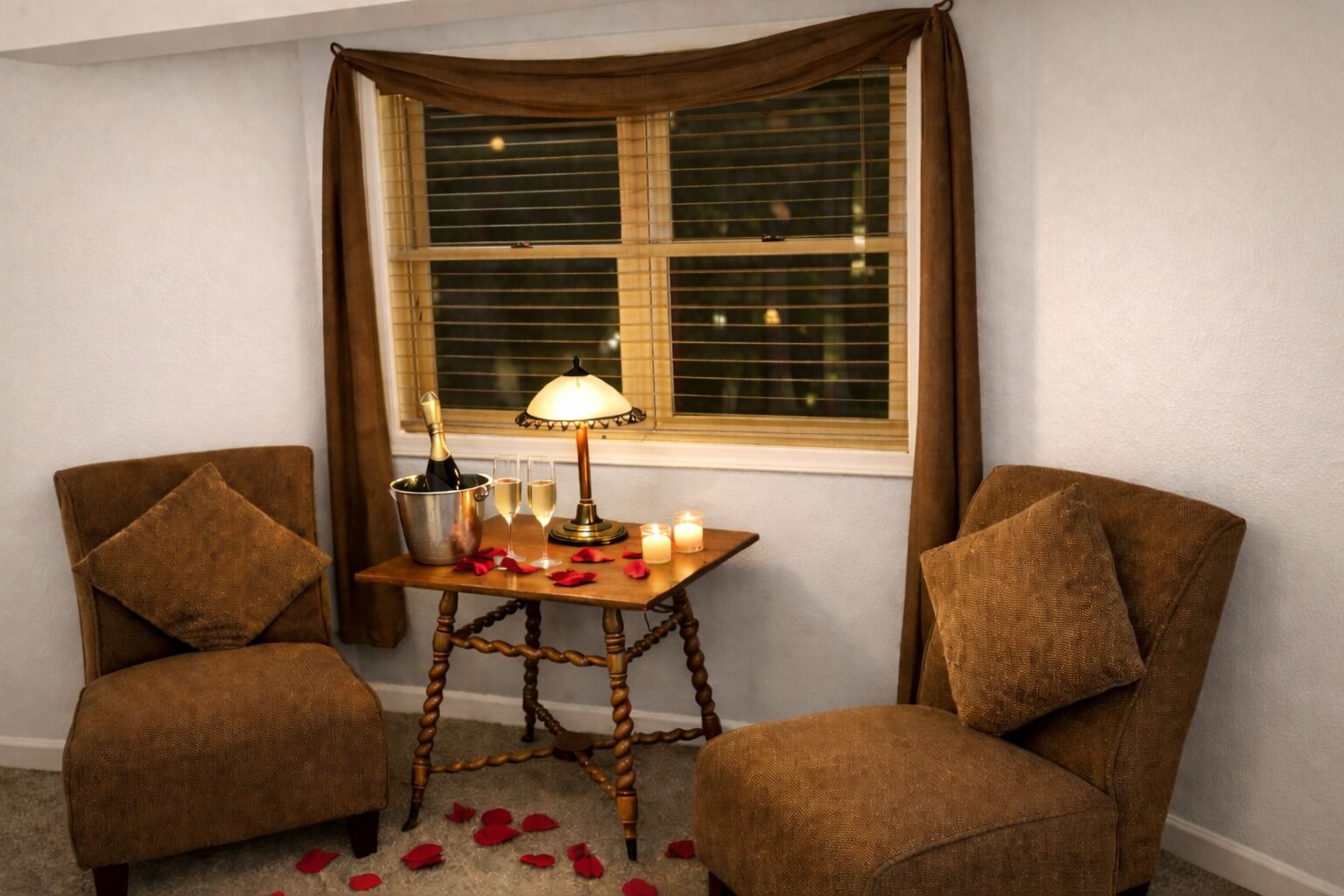 Una habitación de esquina con dos sillones de cuero marrón, una pequeña mesa de madera con una lámpara, una botella de champán, copas y una vela encendida.