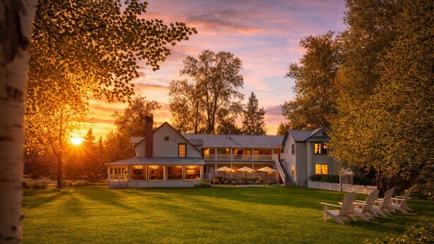 Une grande maison à deux étages dotée d’un patio couvert et d’une pelouse bien entretenue.