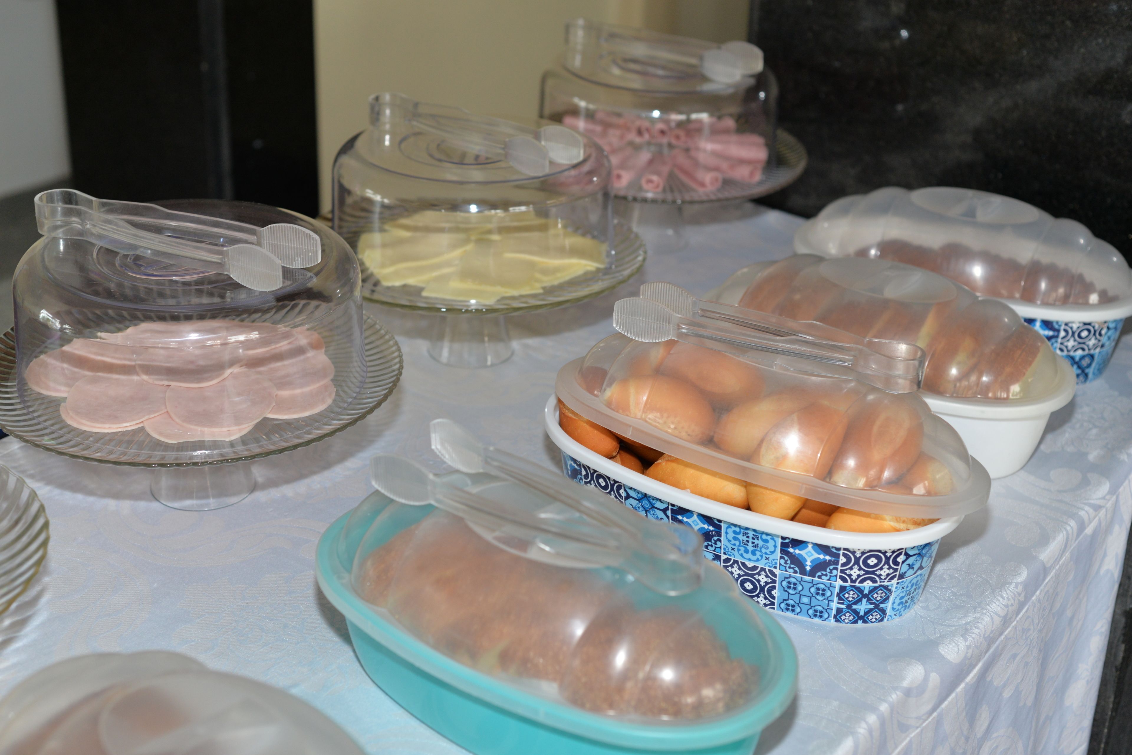 Una mesa de buffet con diversos alimentos en recipientes cubiertos.