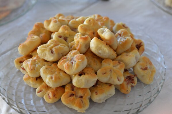Uma tigela de vidro cheia de pequenos doces dourados.