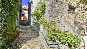 Una estrecha escalera de piedra que sube hacia un edificio con una ventana pequeña y un letrero que dice "PRIVATE".