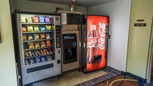 A vending machine with snacks and an ice dispenser, and a Coca-Cola vending machine.
