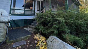 Ein zweistöckiges Haus mit überdachter Veranda und sichtbarer Terrasse.