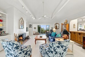 A spacious living room with a fireplace, seating area, and a view of the outdoors.