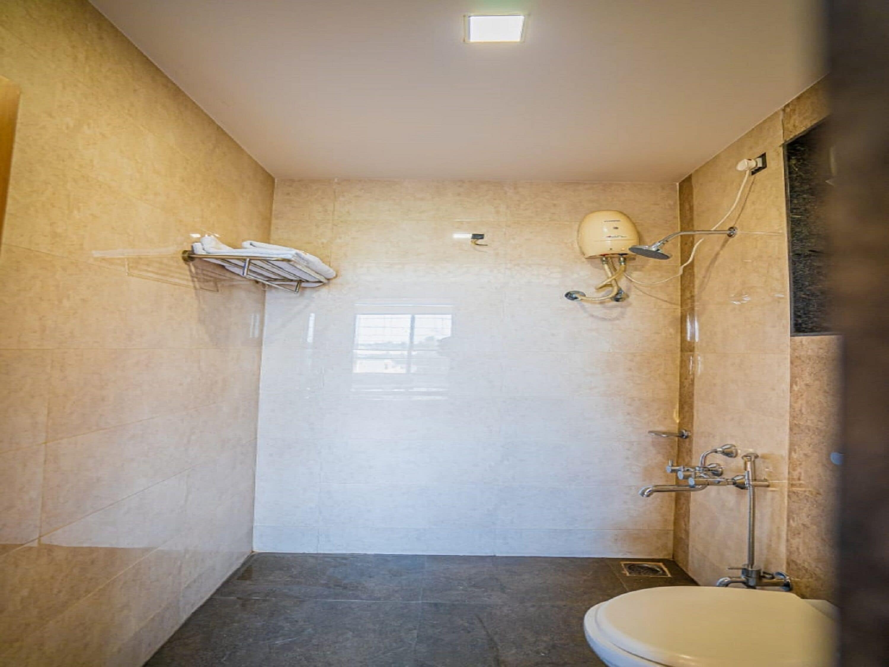 Une salle de bain équipée de toilettes, d’une douche et d’un porte-serviettes.