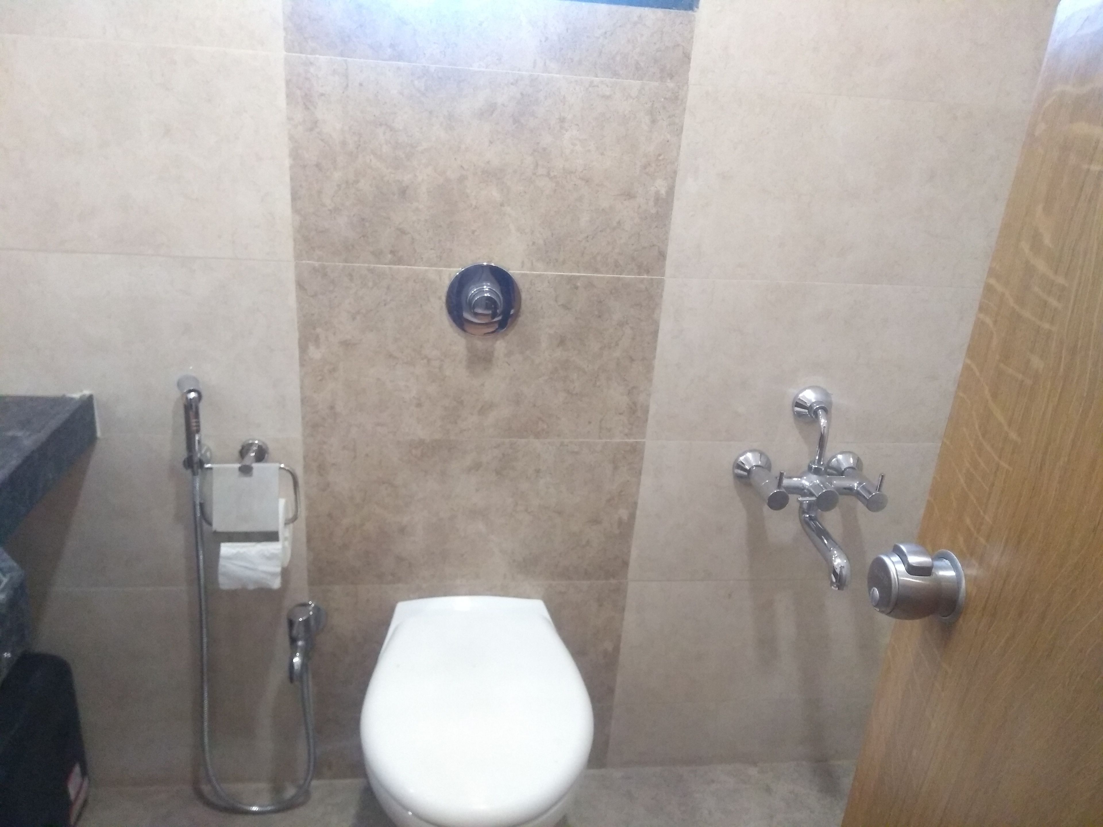 Un baño pequeño con inodoro, ducha y dispensador de toallas.