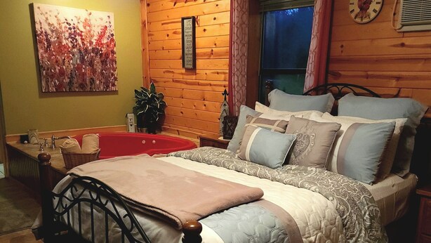 Un dormitorio con una cama, una mesita de noche, un reloj de pared y un cuadro.