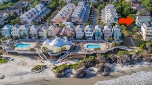 Luftaufnahme eines Küstenhotels mit mehreren Gebäuden, einem Strand und einem Poolbereich.