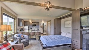 A cozy bedroom with a bed, a TV, a sofa, and a dining area.