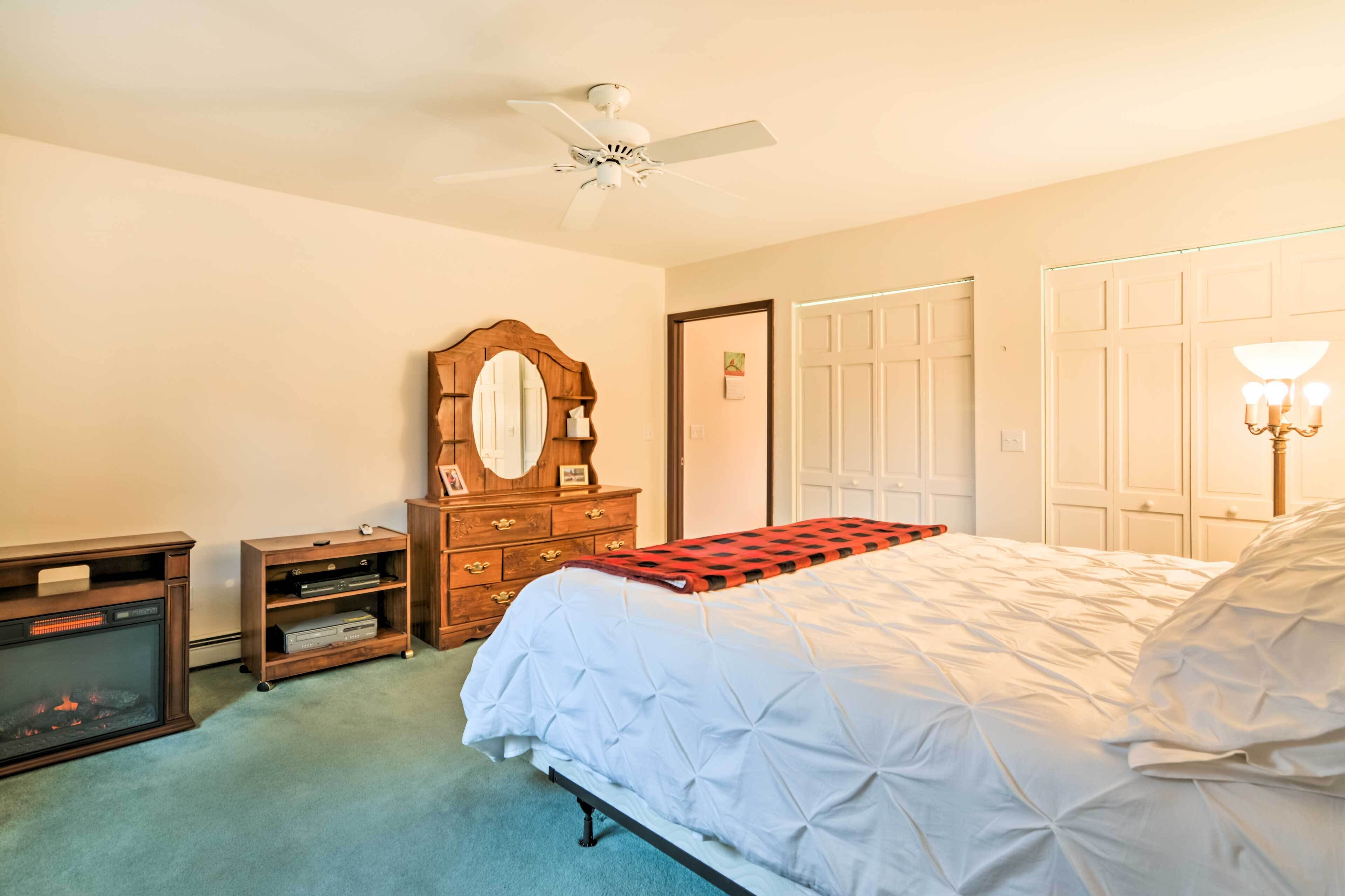 Un dormitorio con cama, cómoda, espejo y ventilador de techo.