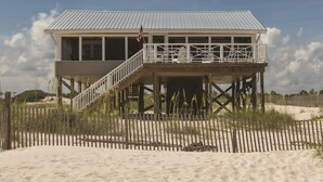 A beach house with a balcony and a flag.