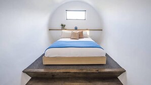 A modern bedroom with a curved ceiling, a single bed with a blue and white bedding, a small bedside table, and a window above the bed. - Yellow Door Coburg | Boutique Accommodation | Sleeps up to 16 guests (Coburg)