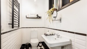 Une salle de bain équipée de toilettes, d’un lavabo et d’un porte-serviettes.