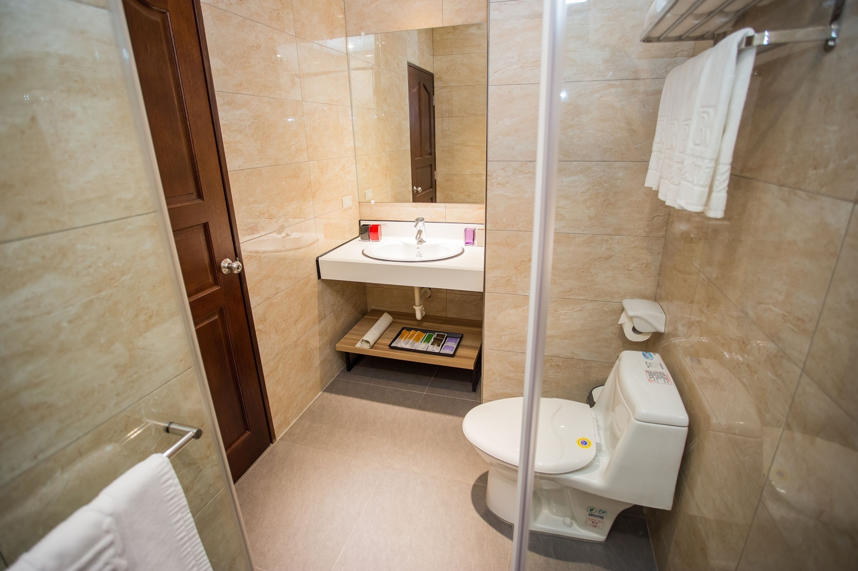 A compact bathroom with a toilet, sink, and shower area.