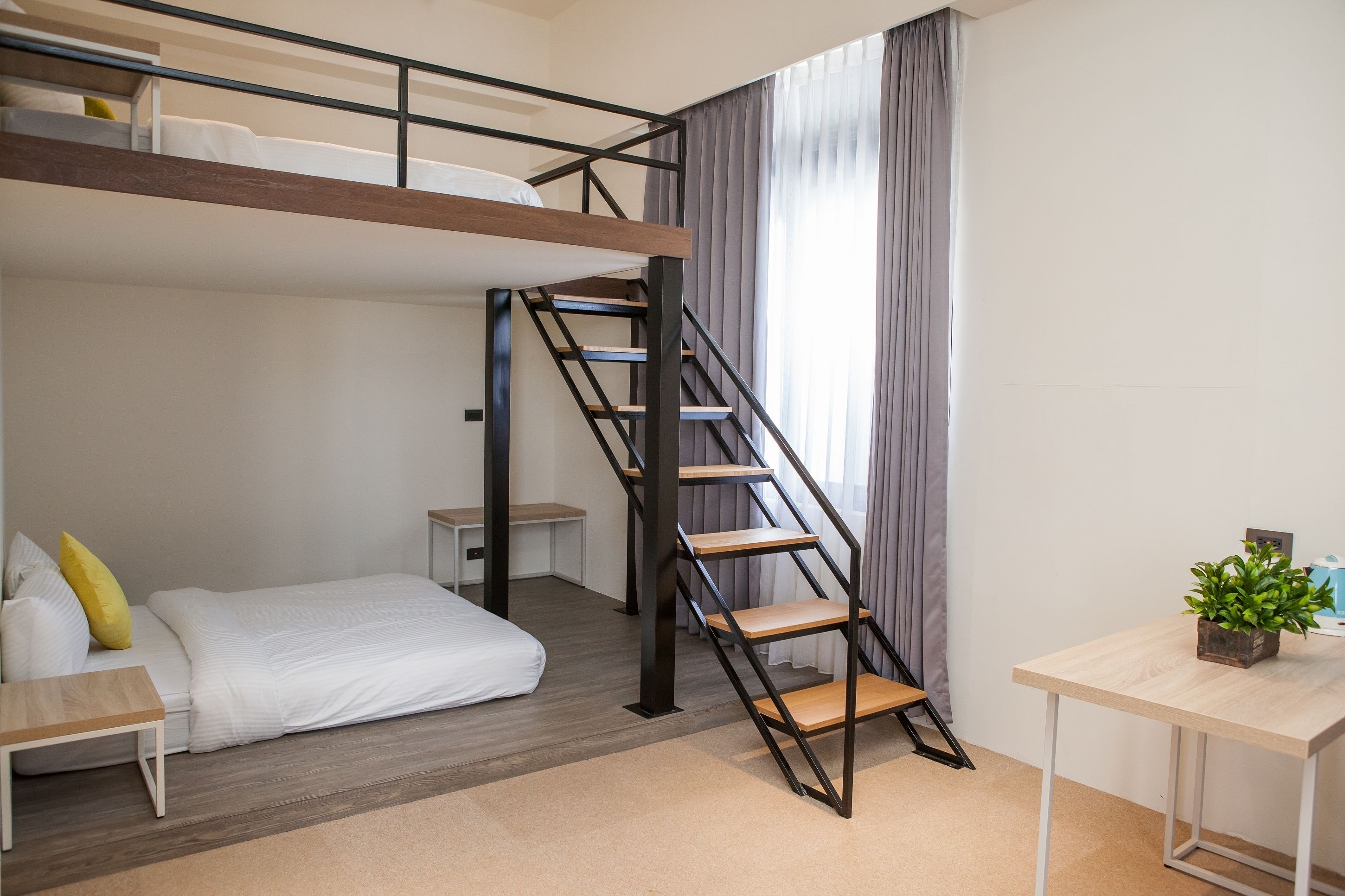 Quarto compacto com beliche, escrivaninha, mesinha e escada.