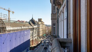 Straßenansicht mit Gebäuden, einem Baukran und einer blauen Fliesenwand.