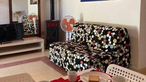 A cozy living room with a sofa, a coffee table with breakfast items, a painting on the wall, and a staircase. -  "Little cottage
 surrounded by olive and almond trees (Noto)