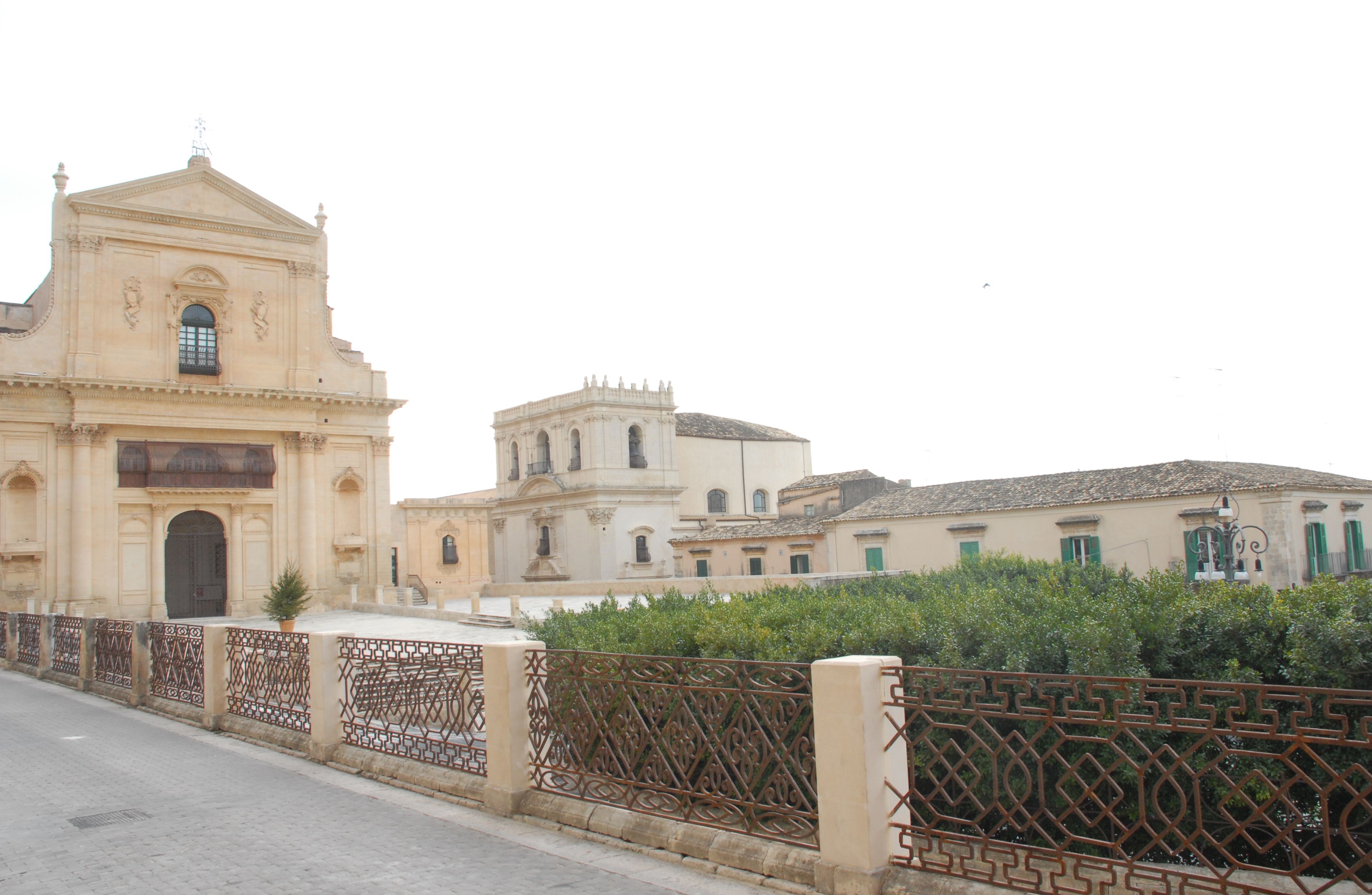 A historic building with a prominent entrance and a bell tower.