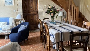 A dining area with a wooden table, chairs, and a staircase.