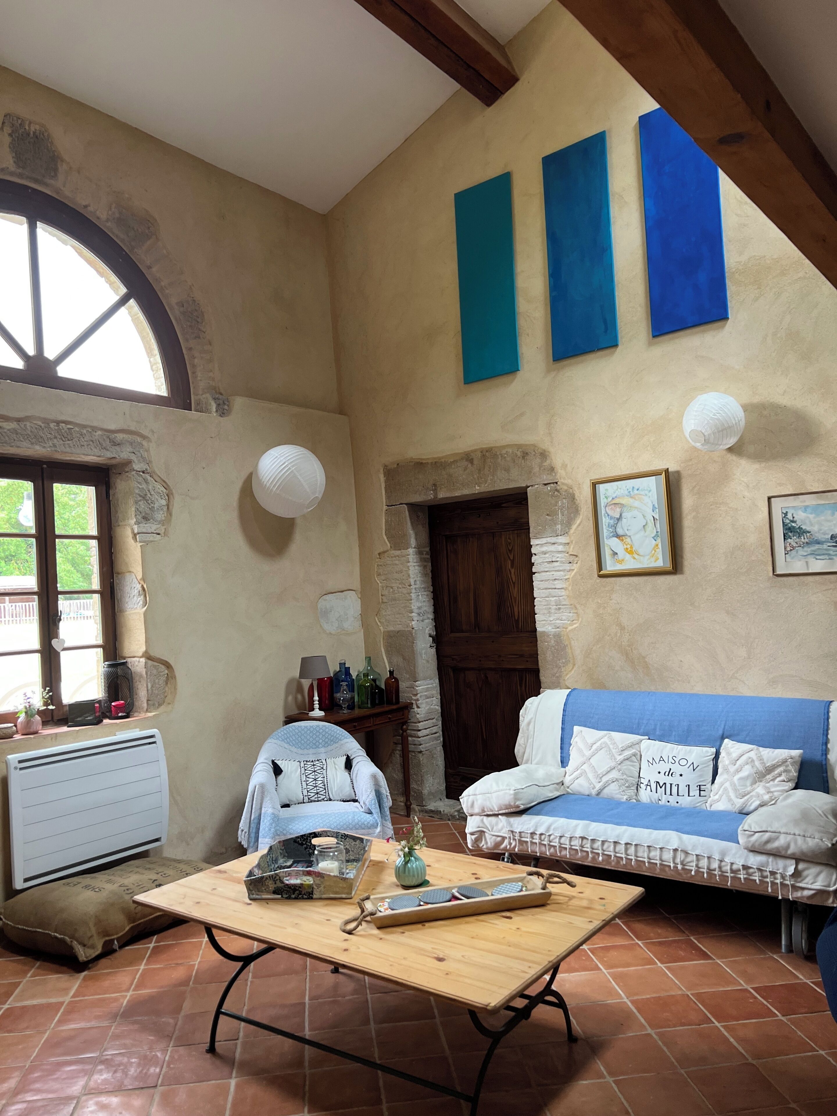 Une pièce chaleureuse avec une table en bois, un canapé bleu et une cheminée en pierre.